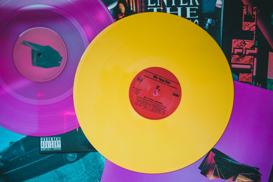 A close-up of a vinyl record spinning on a turntable, with the artistic, minimalist album cover of Syntax and Silence resting nearby.