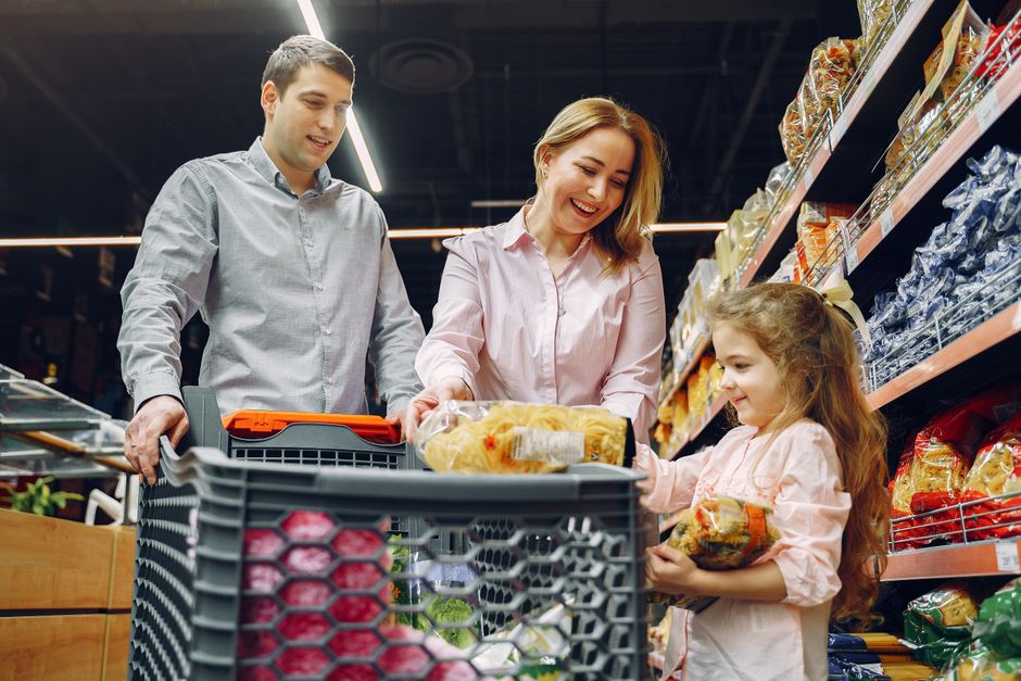 A family shopping for fresh produce in a New York grocery store, using an EBT card at checkout