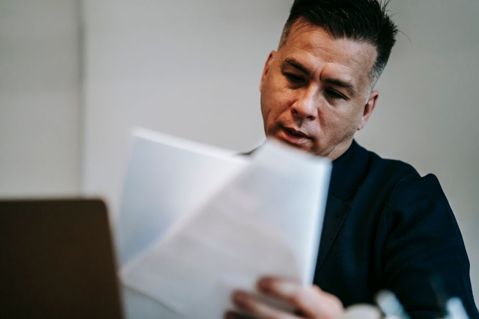 A person reviewing financial documents and bills at a desk