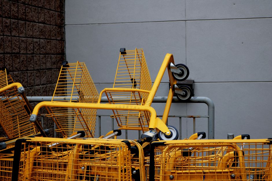 A shopping cart filled with fresh fruits and vegetables at a Whole Foods store