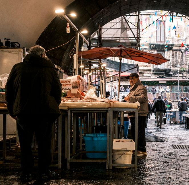 A Sicilian market scene with locals chatting